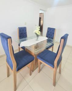 a dining room table with blue chairs and a glass table at Acogedor y Residencial piso 3 in Cartagena de Indias