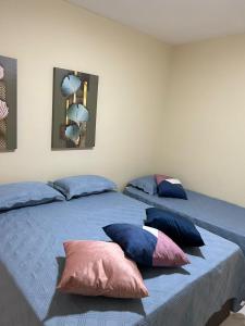 two beds in a room with pillows on them at casa em Brotas 08 in Brotas