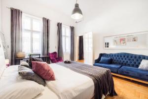 1 dormitorio con 2 camas y sofá azul en Historic Penthouse with Sauna & Jacuzzi @Downtown, en Budapest