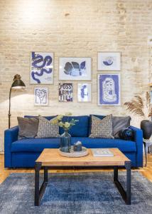 Sofá azul en la sala de estar con mesa de centro en Historic Penthouse with Sauna & Jacuzzi @Downtown, en Budapest