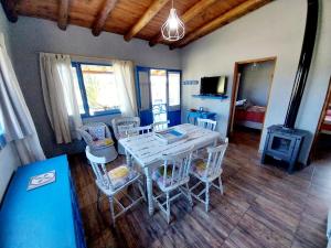 a dining room with a table and chairs and a fireplace at Cabaña Gota de Rocio en finca Margarita in San Rafael