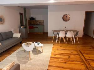ein Wohnzimmer mit einem Sofa, einem Tisch und Stühlen in der Unterkunft Le chalet percheron in La Loupe