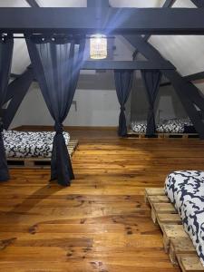 a room with two beds and a wooden floor at Le chalet percheron in La Loupe