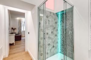 a glass shower in a white bathroom with wood floors at RIPETTA234 in Rome