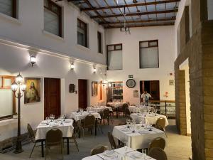 a restaurant with white tables and chairs and a clock at Hotel Colonial - Casa Francisco in Quito