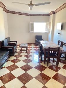 sala de estar con suelo a cuadros, mesa y sillas en شقق فندقيه برج شيفورليه حي الدولار en Marsa Matruh