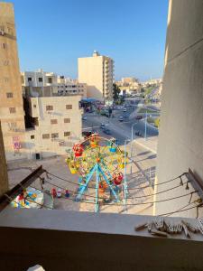een uitzicht op een reuzenrad in een stad bij شقق فندقيه برج شيفورليه حي الدولار in Marsa Matruh