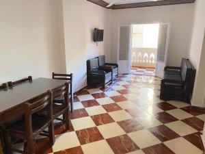 uma sala de estar com cadeiras, uma mesa e um piso de xadrez em شقق فندقيه برج شيفورليه حي الدولار em Marsa Matruh