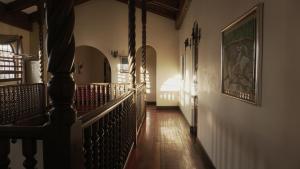 um corredor de uma casa com uma escada e um quadro na parede em Hostel Casa Colon em San José