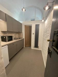 a kitchen with white cabinets and a glass ceiling at Victorian Police Station Apartment in Launceston