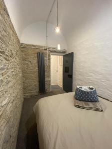 um quarto com uma cama numa parede de tijolos em Victorian Police Station Apartment em Launceston