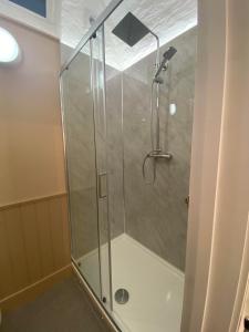 a shower with a glass door in a bathroom at Victorian Police Station Apartment in Launceston