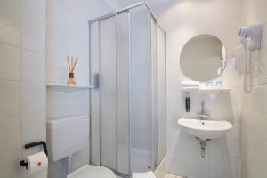 a bathroom with a shower and a toilet and a sink at Hotel Berliner Bär in Berlin