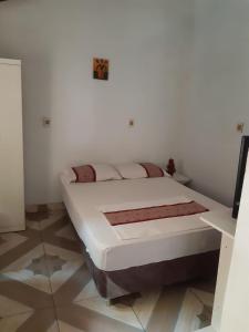 a bed in a room with white walls and tile floors at Monoambiente semi independiente en Asu-Py in Asunción