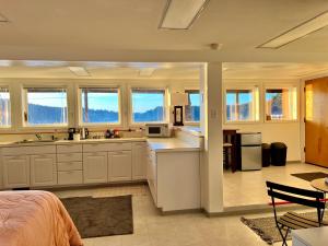 eine große Küche mit weißen Schränken und Fenstern in der Unterkunft The Starboard Side Room - Cliffside, Ocean Views in Kodiak