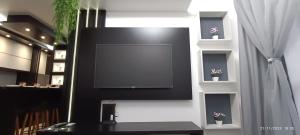 a flat screen tv on a wall with potted plants at Apto 5 Estrelas no Centro de Pelotas in Pelotas +9 photos