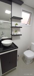 een witte badkamer met een wastafel en een toilet bij Apto 5 Estrelas no Centro de Pelotas in Pelotas
