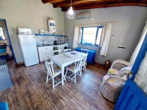 a kitchen with a table and chairs and a refrigerator at Cabaña Gota de Rocio en finca Margarita in San Rafael