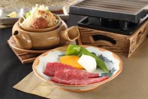 a plate of food with meat and vegetables on a table at Hotel Binario Saga Arashiyama in Kyoto