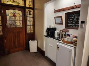 eine Küche mit einer Theke und einer Tür mit Buntglas in der Unterkunft The Fern & Thistle Luxury Accommodation- Drinks, Hotpool, Sauna in Balclutha