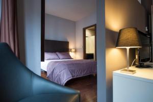 um quarto de hotel com uma cama e um espelho em MyHouseSpain - Apartamentos Moros 41 em Gijón