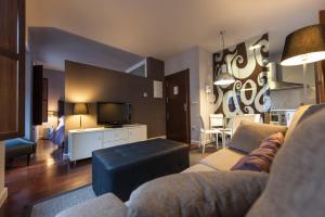 sala de estar con sofá y TV en MyHouseSpain - Apartamentos Moros 41 en Gijón