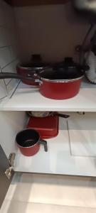 een plank met drie potten en pannen in een keuken bij Apto 5 Estrelas no Centro de Pelotas in Pelotas
