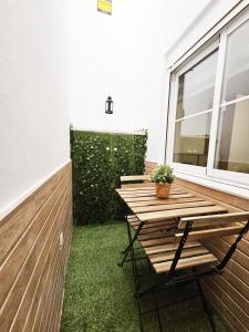 un tavolo in legno e una sedia sul balcone. di Elegante apartamento de diseño. a Almería