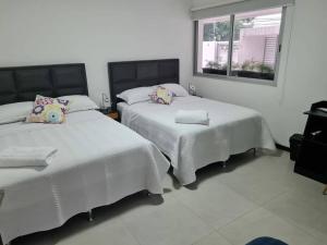 a bedroom with two beds and a window at Departamento Familiar en Equipetrol in Santa Cruz de la Sierra
