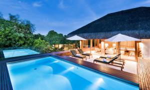 - une piscine avec des chaises longues et des parasols à côté d'un complexe dans l'établissement Pool Villas Tivoli Ecoresort, à Praia do Forte