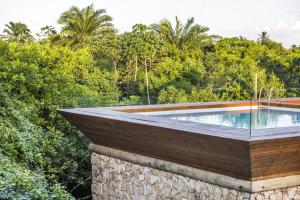 une piscine sur un immeuble avec des arbres en arrière-plan dans l'établissement Pool Villas Tivoli Ecoresort, à Praia do Forte 8 autres photos