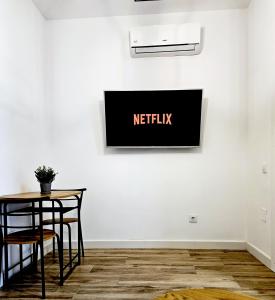 a table and chairs against a wall with a netflix sign at Elegante apartamento de diseño. in Almería