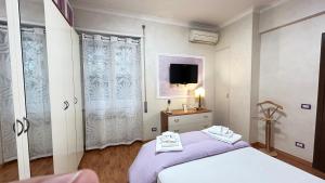ローマにあるAngel's houseのベッドルーム1室(ベッド1台、壁掛けテレビ付)