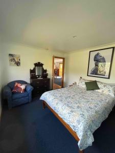 1 dormitorio con 1 cama y 1 silla en Vayu Vista, en Princetown