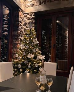 een kerstboom voor een tafel met wijnglazen bij Madame Parisienne in Nafpaktos