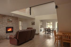 - un salon avec un canapé et une cheminée dans l'établissement Finn Farm Cottage, à Ballybofey