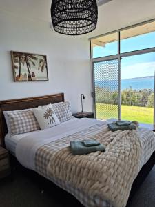 a bedroom with a large bed with two towels on it at ON THE WATERS EDGE in Port Lincoln