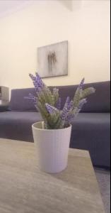 biała waza z fioletowymi kwiatami na stole w obiekcie Iasonas - 2BR Apartment - Explore Center by foot - Close to Aristotelous square w Salonikach