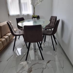 a dining room with a white table and chairs at Les Hirondelles in Andolsheim