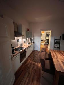 cocina con mesa y suelo de madera en Dein Ankerplatz in Mülheim Ruhr - Traditionelle Zechenhaushälfte, en Mülheim an der Ruhr