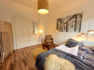un dormitorio con una cama y una silla en Dein Ankerplatz in Mülheim Ruhr - Traditionelle Zechenhaushälfte, en Mülheim an der Ruhr