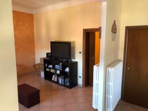 een woonkamer met een flatscreen-tv op een standaard bij Casa Zanardi 2.0 in Bologna