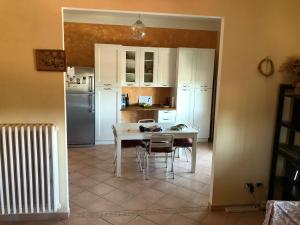 una cucina con tavolo, sedie e frigorifero di Casa Zanardi 2.0 a Bologna