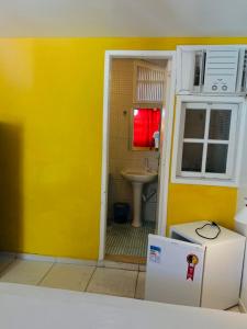 baño con pared amarilla y lavamanos en SOL, en Búzios