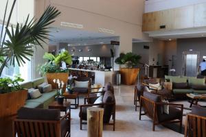 a lobby with chairs and tables and a bar at Hilton Garden Inn Veracruz Boca del Rio in Veracruz