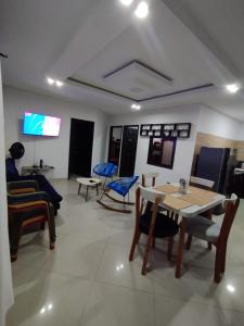 a room with a table and chairs and a tv at Hermosa y acogedora casa in Acacías