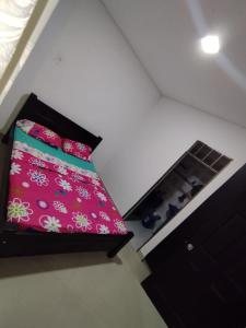 1 dormitorio con 1 cama con manta rosa en Hermosa y acogedora casa, en Acacías