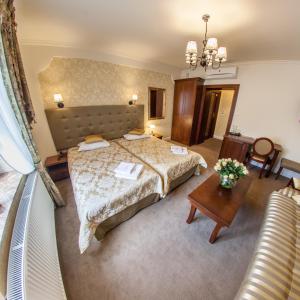 a hotel room with a bed and a table at Hotel Fryderyk in Rzeszów