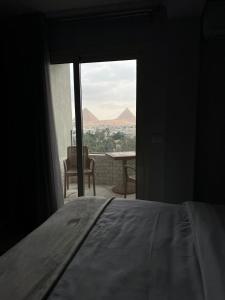 a bedroom with a bed and a window with a view at pyramids grand museum inn in Cairo