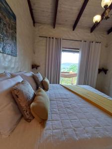 een slaapkamer met een groot bed en een groot raam bij Le Jardim in Alto Paraíso de Goiás